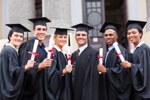 group of young college graduates and professor at graduation